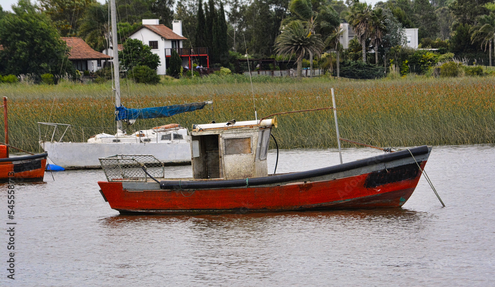 Fototapeta premium Fishing boats in the harbor at dusk with a lagoon with a beautiful sunset