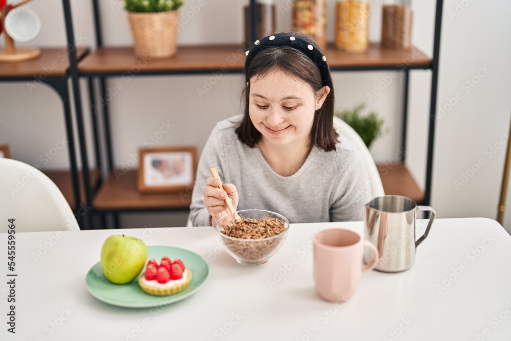 Young woman with down syndrome smiling confident having breakfast at home Young woman with down syndrome smiling confident having breakfast at home