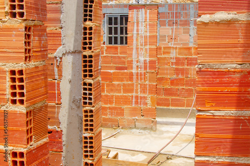 Brick wall under construction of brazilian house, brick under construction in brazil. blocks or bricks (masonry) of red clay on a wall, in the work of Brazilians. photo