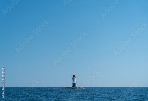 navigation buoy or small beacon on tiny island in the calm blue sea.