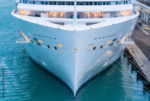 Close up of the bow cruise ship docked in the harbor, dusk, evening. Concept of travel and vacation