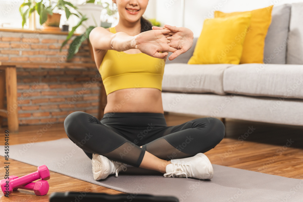 Obraz premium Beautiful fitness asian young woman, girl wearing sportswear training strength muscles workout, exercise training on carpet in living room at home for healthy body strong athletic fit active lifestyle