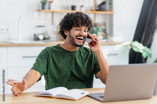 Obraz na plátně Happy young man freelancer or aspiring entrepreneur working remotely online at h