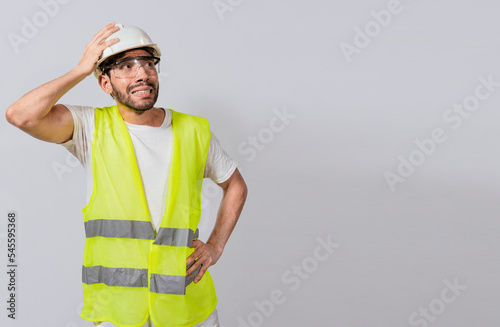 Worried builder engineer holding his head. Worried engineer man looking up. Troubled young engineer holding his head looking up. Engineer problems concept