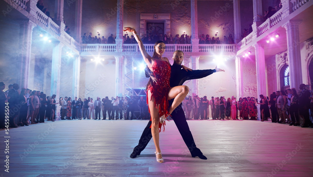 Couple dancers perform latin dance on large professional stage. Ballroom dancing. - obrazy, fototapety, plakaty 