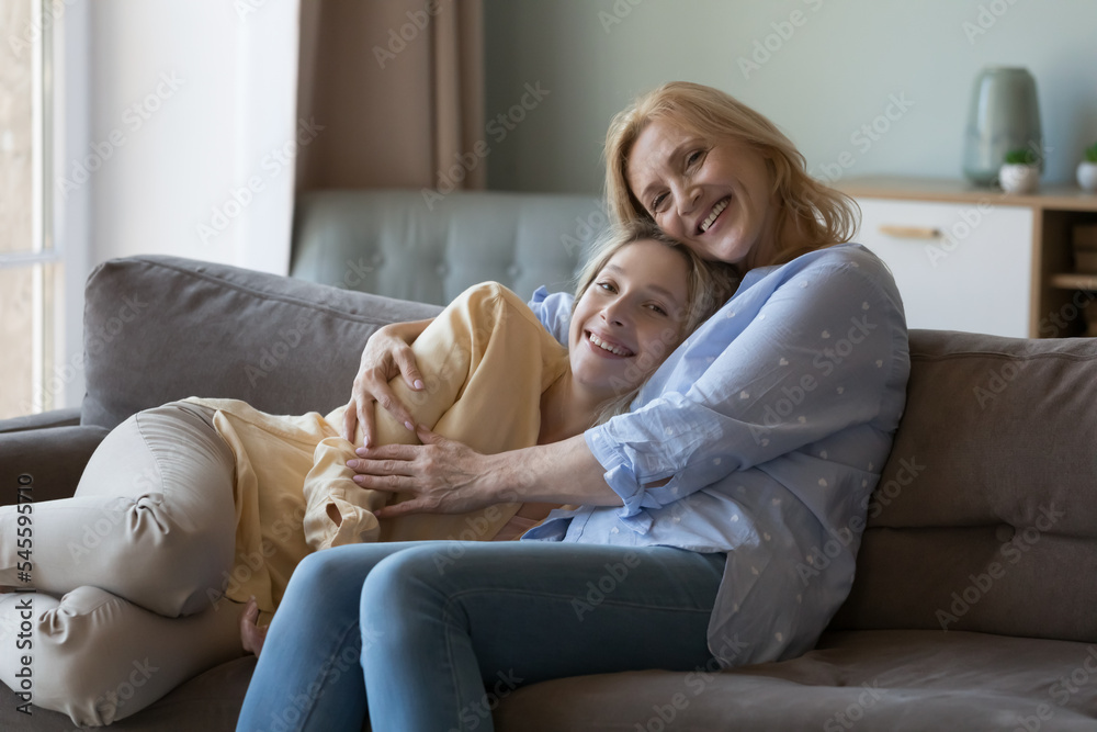 Happy mature mom cuddling grown up millennial blonde daughter, express love, care, enjoy good friendly harmonic relationships, spend leisure, appreciate time together. Family bond and ties, motherhood Happy mature mom cuddling grown up millennial blonde daughter, express love, care, enjoy good friendly harmonic relationships, spend leisure, appreciate time together. Family bond and ties, motherhood