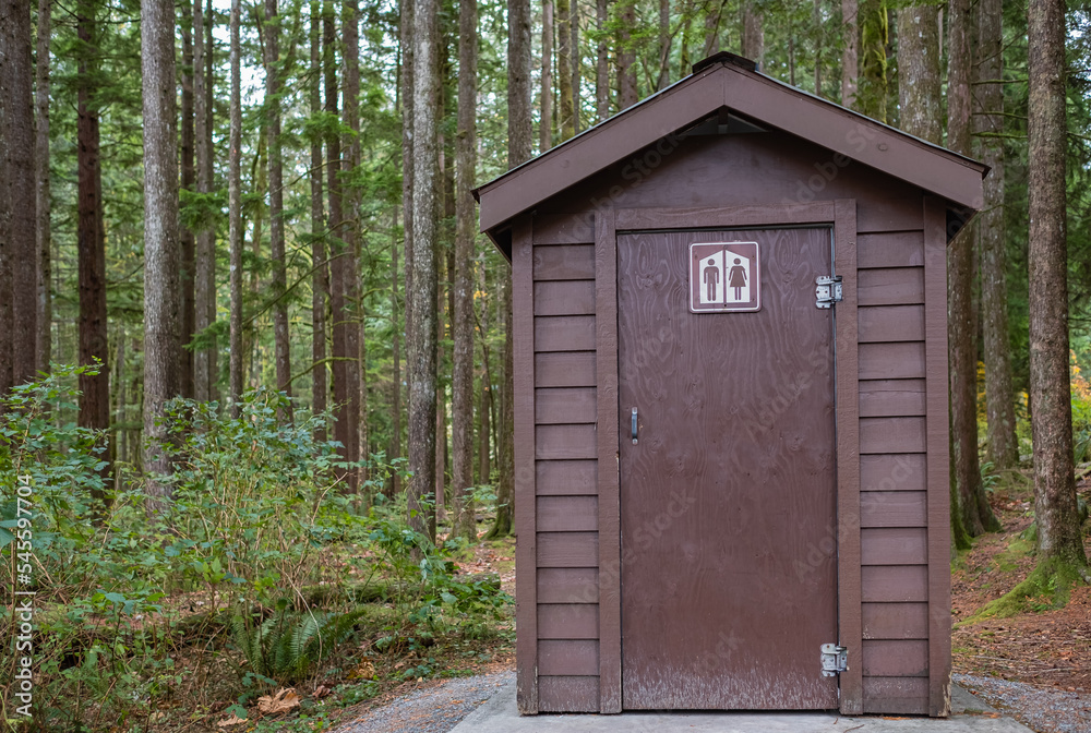 Public toilet in park. Summer day Wooden restroom or toilet building in remote forest in park. Bathrooms or WC Public toilet in park. Summer day Wooden restroom or toilet building in remote forest in park. Bathrooms or WC