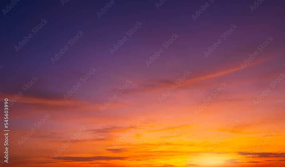 Colorful dusk sky background after sundown with beautiful orange sunlight clouds on blue twilight sky in wide screen view