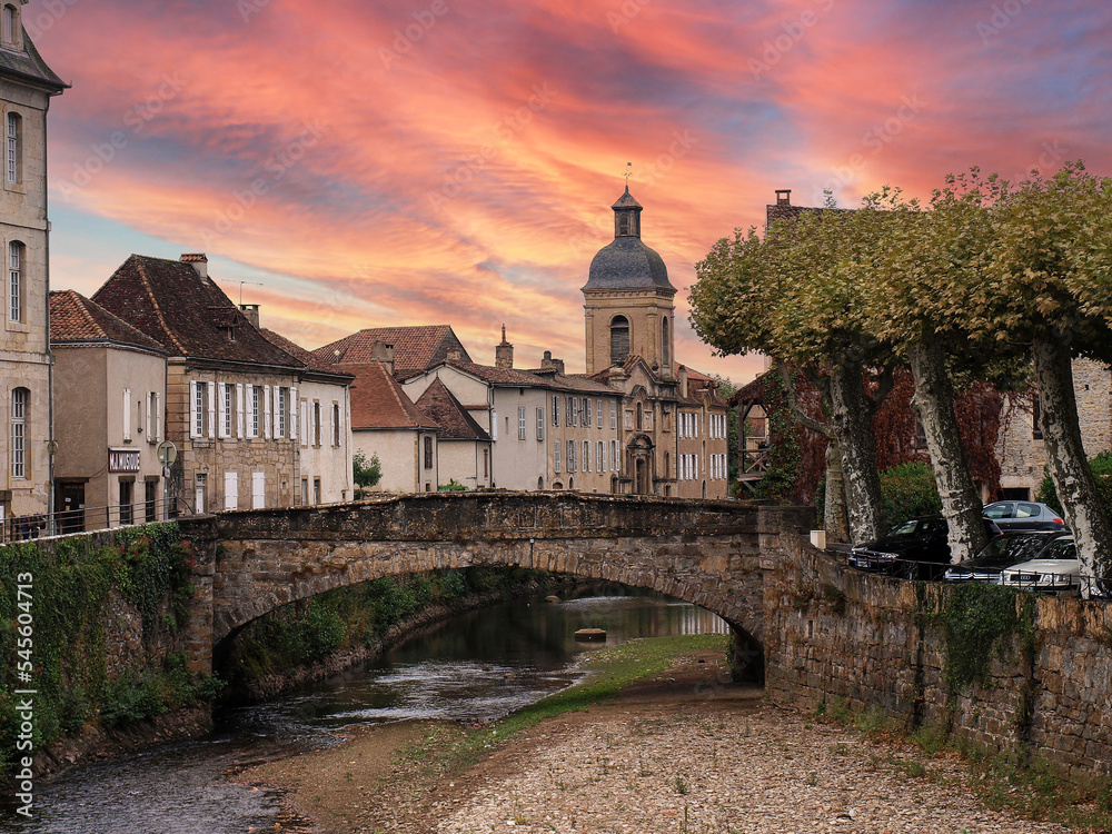 Saint-Céré village médiéval au nord-est du Lot en Occitanie. Ruisseau la Bave et Quai des Récollets et son église