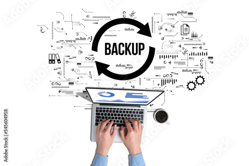 Data backup for data recovery to original or new location. The person is working on a laptop.