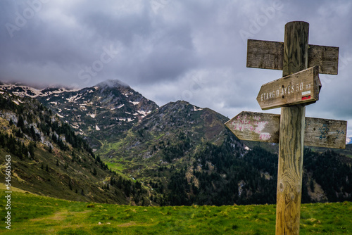Trail indication signs with snowy mountains in the background near Ayes lake the French Pyrenees mountain range © Pernelle Voyage