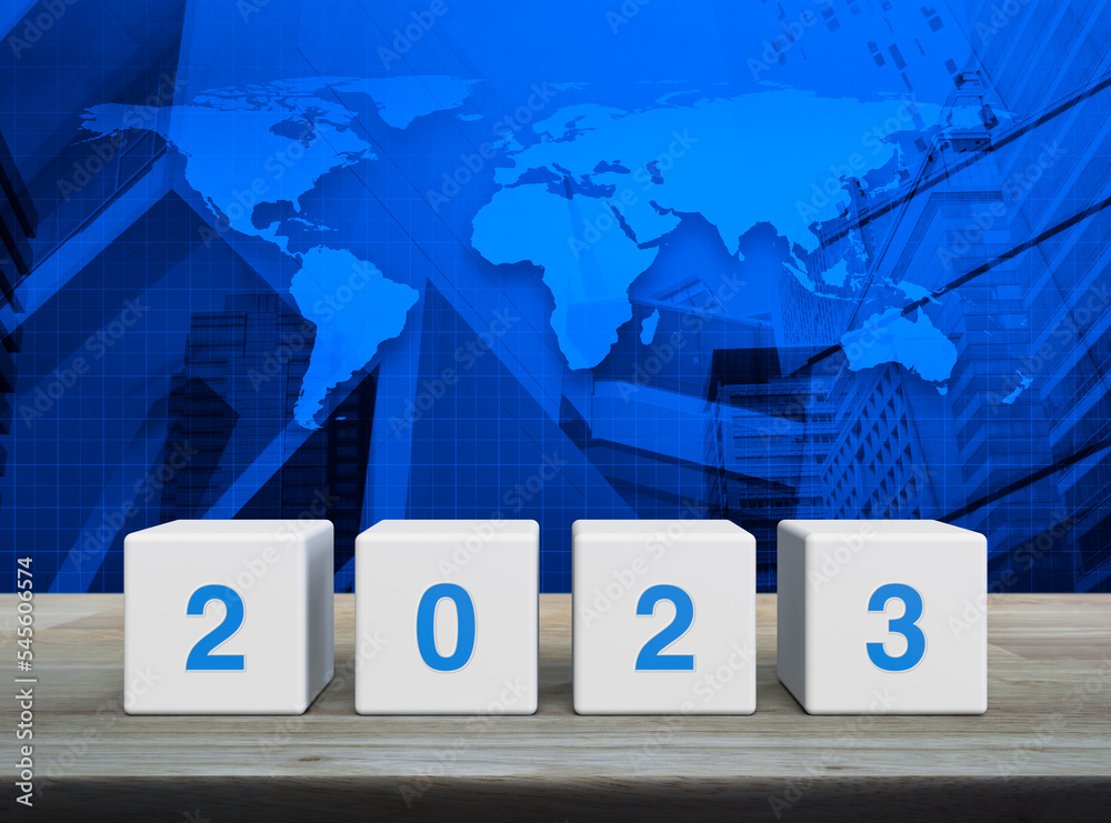 2023 letter on white block cubes on wooden table over world map, modern office city tower and skyscraper, Happy new year 2023 cover concept, Elements of this image furnished by NASA
