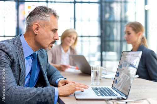 Businessman with colleagues in the background in office.