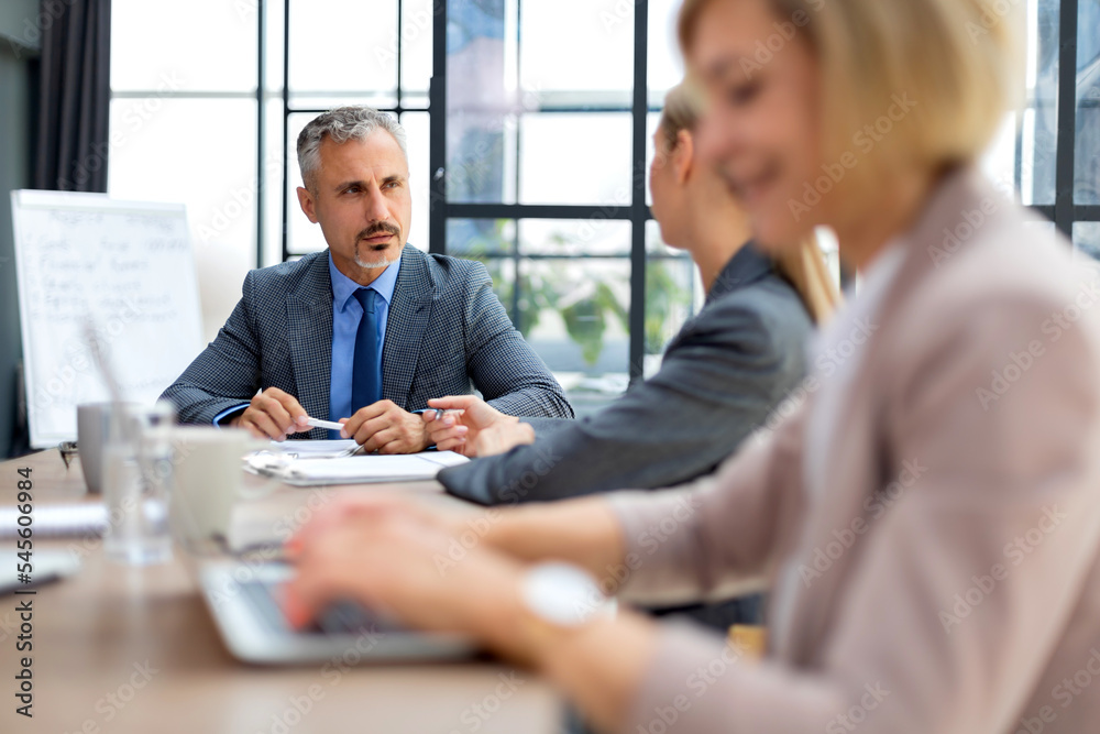 Business team discussing together business plans in office. Business team discussing together business plans in office.