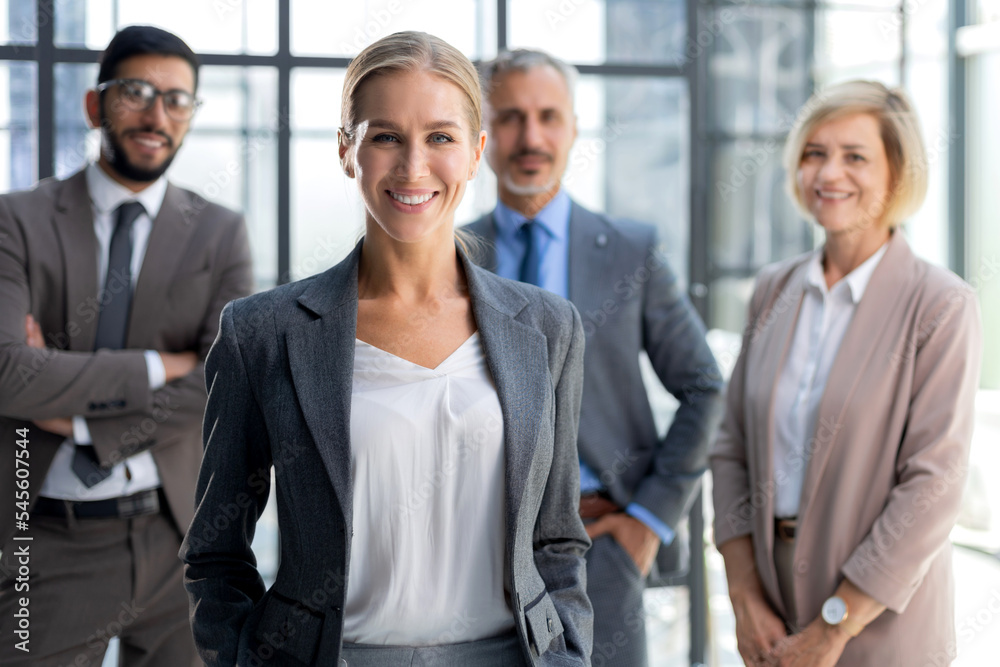 Businesswoman with colleagues in the background in office. Businesswoman with colleagues in the background in office.