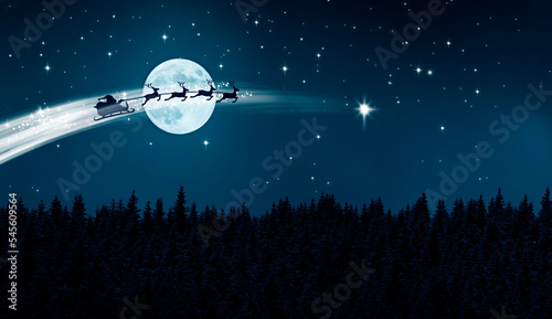 Santa Claus im Schlitten über einer Schneelandschaft bei Nacht