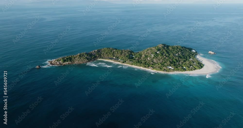 Aerial panning view of the luxury resort on Cousine Island, with a solar farm, villas and private beach, Seychelles Aerial panning view of the luxury resort on Cousine Island, with a solar farm, villas and private beach, Seychelles
