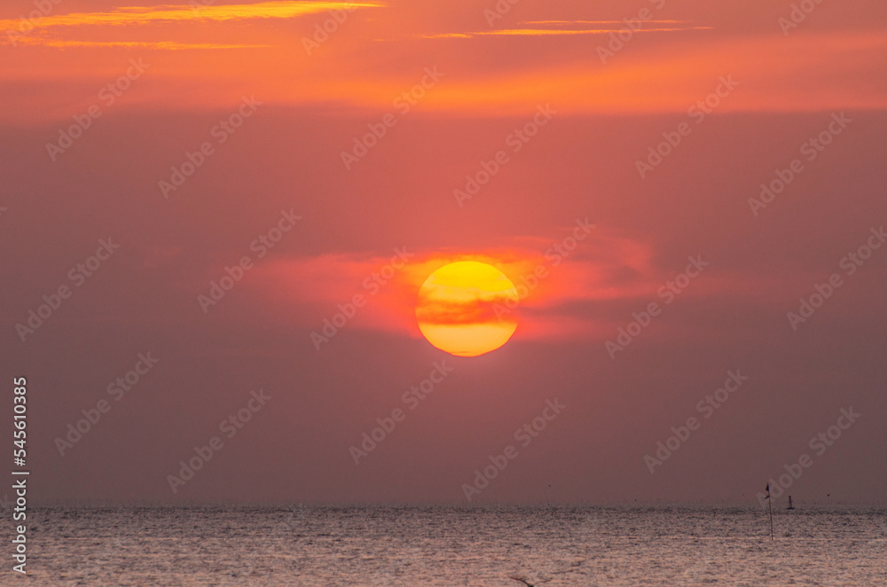 Idyllic sunrise with huge sun rising over the sea