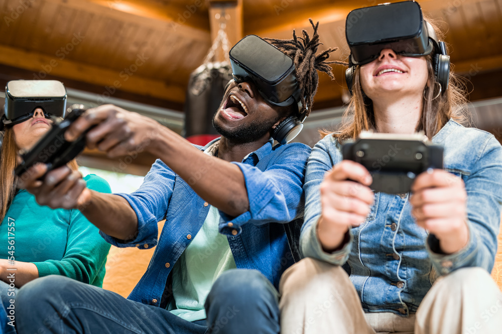 Happy friends having fun playing modern games with virtual simulator ...