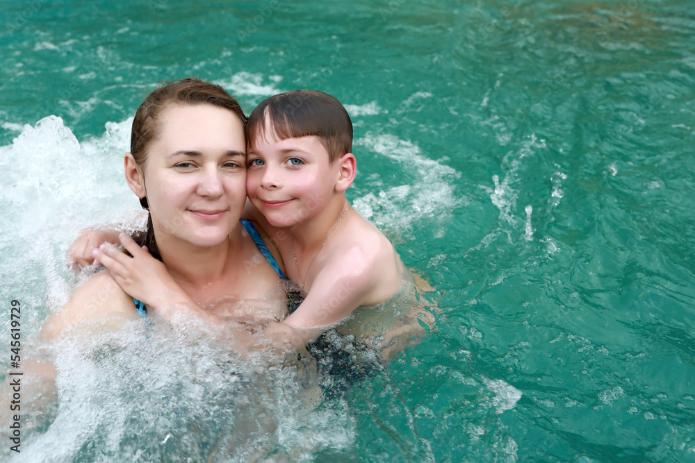 Mother and son do their chests hydromassage in hot pool Mother and son do their chests hydromassage in hot pool