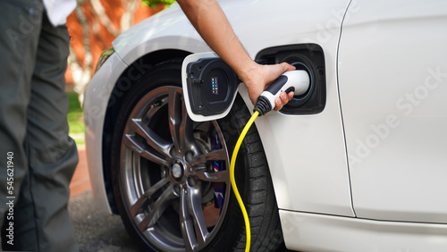 Close up hands charging power EV station for electric car vehicle. New model EV car with technology and energy ecology power for supply to charger. Saving environment and earth Concept