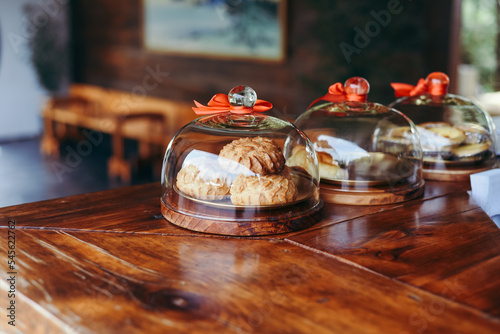 Canvastavla pastries with custard under glass lids on a wooden table