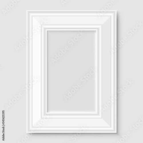 Empty white photo frame with shadow on gray wall.