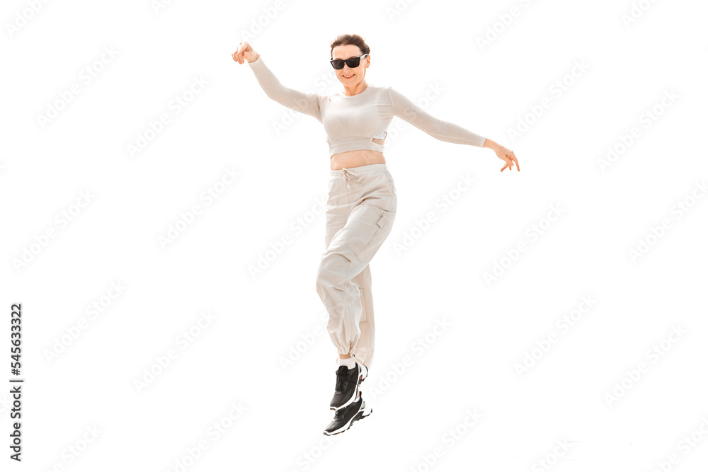 a full-length girl in light comfortable sportswear happily jumps and poses on a white background a full-length girl in light comfortable sportswear happily jumps and poses on a white background