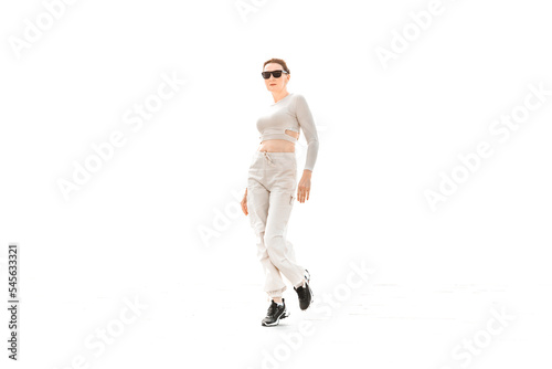 a full-length girl in light comfortable sportswear happily jumps and poses on a white background