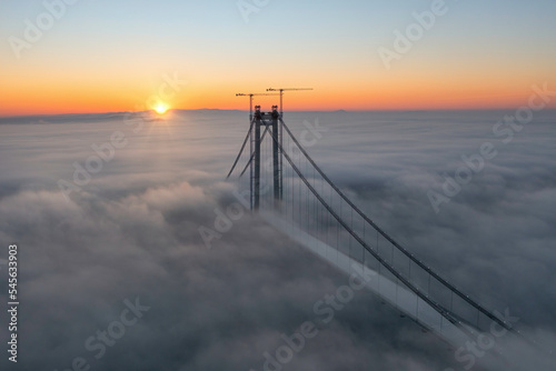 Panoramic aerial drone view from above of the suspended bridge over danube river, under construction, between Braila and Tulcea cities in Romania