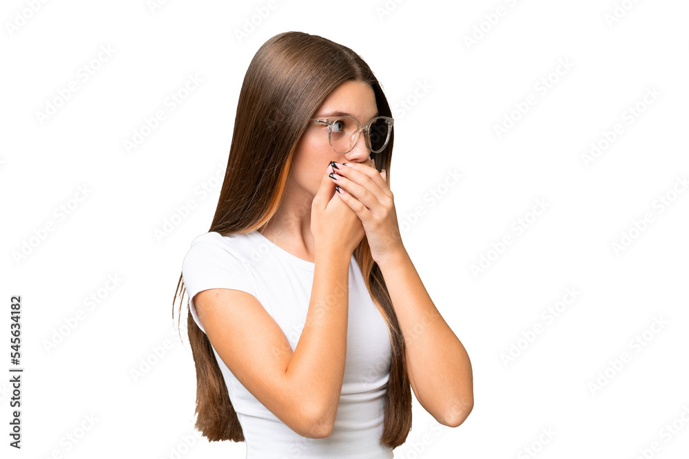 Teenager caucasian girl over isolated background covering mouth and looking to the side Teenager caucasian girl over isolated background covering mouth and looking to the side
