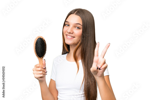 Teenager caucasian girl with hair comb over isolated background smiling and showing victory sign