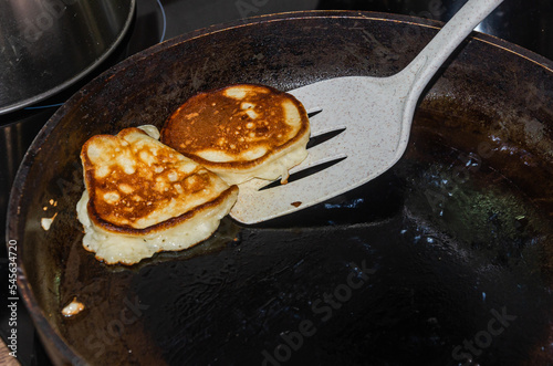 Canvas Print The cook is frying pancakes in a frying pan