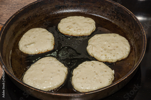Canvas Print The cook is frying pancakes in a frying pan