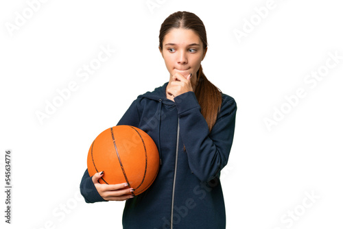Teenager caucasian girl playing basketball over isolated background having doubts and thinking © luismolinero