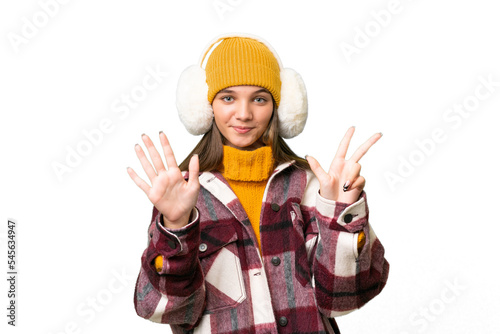 Teenager caucasian girl wearing winter muffs over isolated background counting eight with fingers © luismolinero