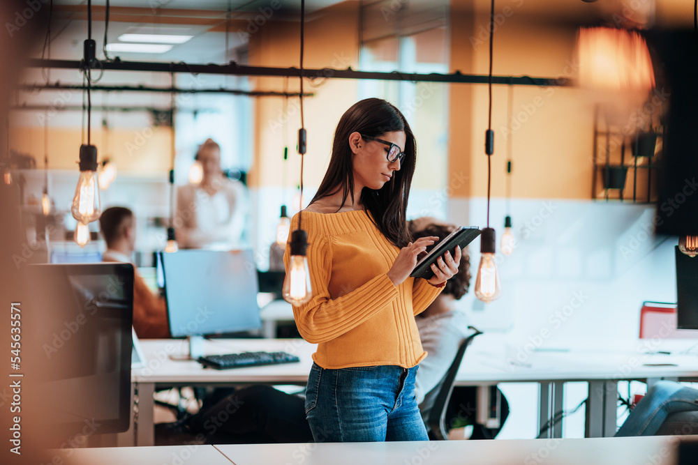 Female boss, manager executive posing in a modern startup office while being surrounded by her coworkers, team. Female boss, manager executive posing in a modern startup office while being surrounded by her coworkers, team.