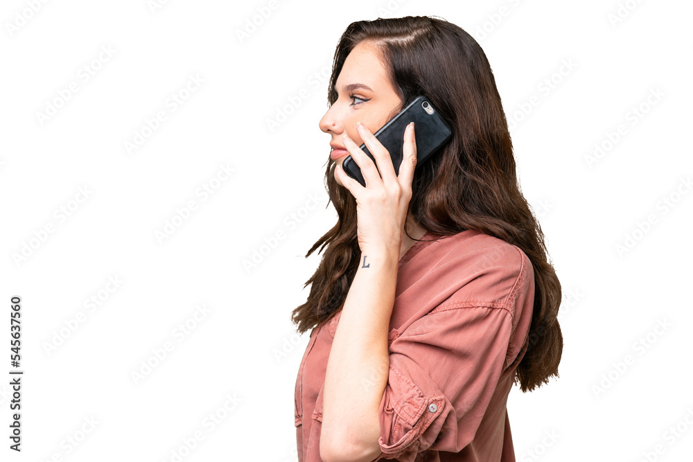 Young caucasian woman over isolated background keeping a conversation with the mobile phone with someone Young caucasian woman over isolated background keeping a conversation with the mobile phone with someone