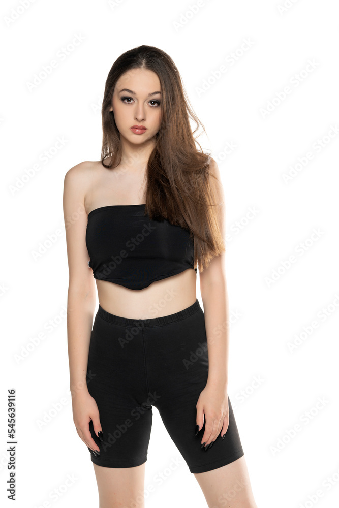 Young woman in black shorts and top posing in the studio Young woman in black shorts and top posing in the studio