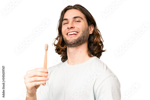 Young handsome man brushing teeth over isolated background smiling a lot