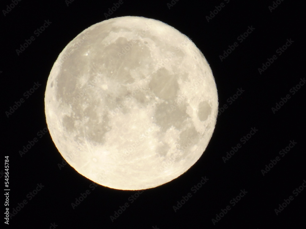 Obraz premium Genova, Italy-July 14, 2022: Beautifull full moon. Summer super moon with dark background behind. Moon detail in summer days.