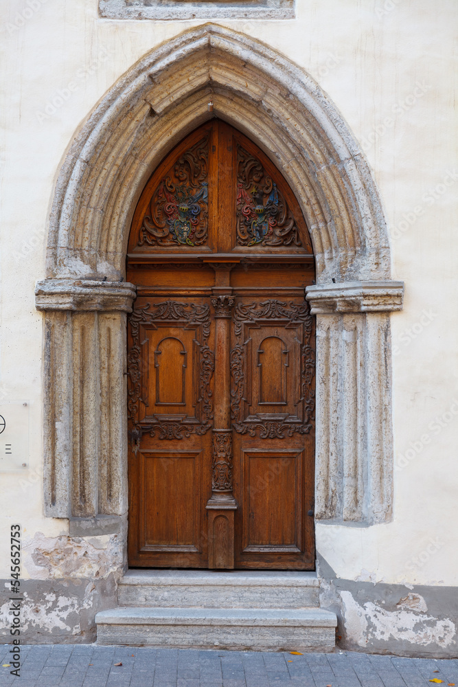 Wooden carved door. Streets of old town of Tallinn. Autumn daytime.