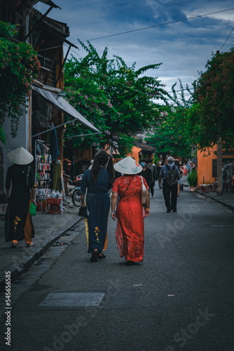 Photograph of a street in Hoi An in Vietnam. Vietnamese women strolling through the city. asian life