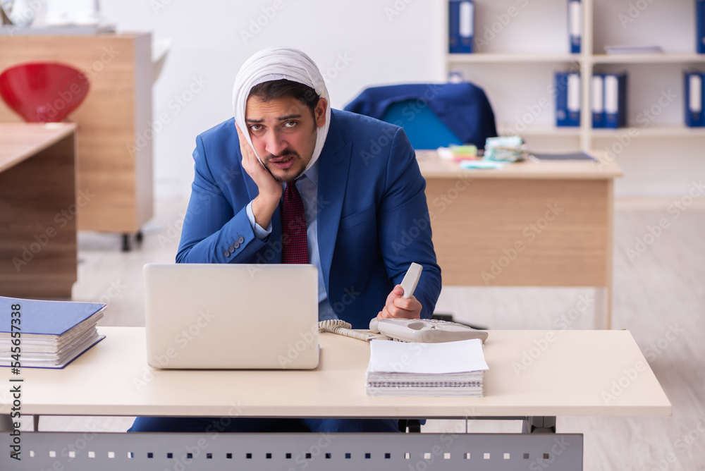 Young male employee suffering from toothache at workplace Young male employee suffering from toothache at workplace