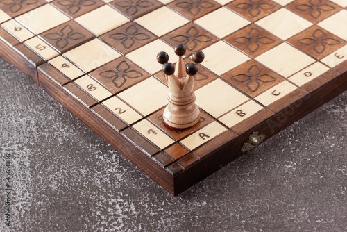 Photography White chess Queen piece hand carved in wood on handmade board
