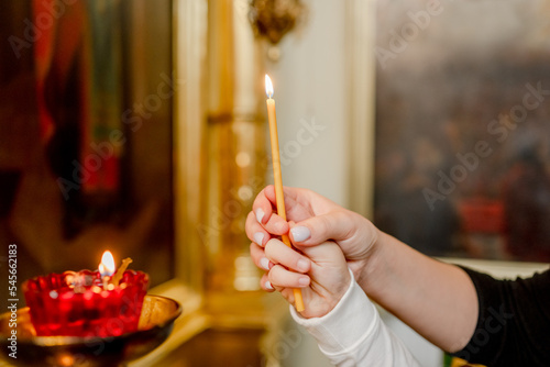 Photography The hand of a woman and a child put a candle in the Church