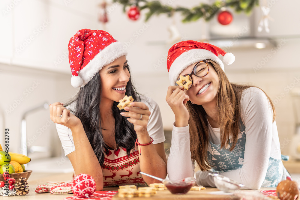 Daughter and mother having fun baking Christmas cakes, girl looking through the baked star. Daughter and mother having fun baking Christmas cakes, girl looking through the baked star.