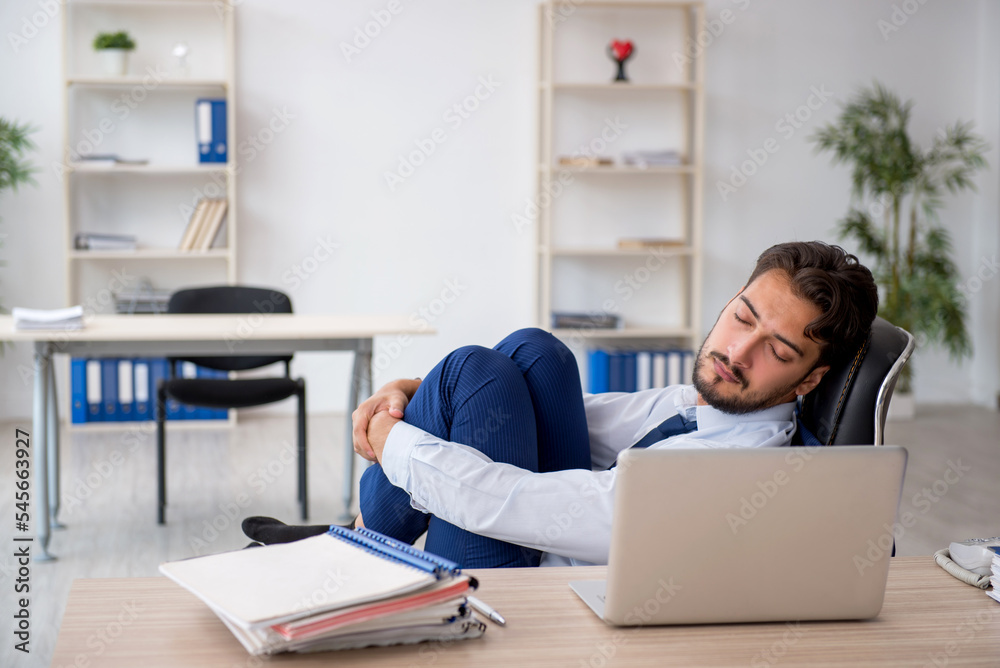 Young male employee extremely tired in the office Young male employee extremely tired in the office