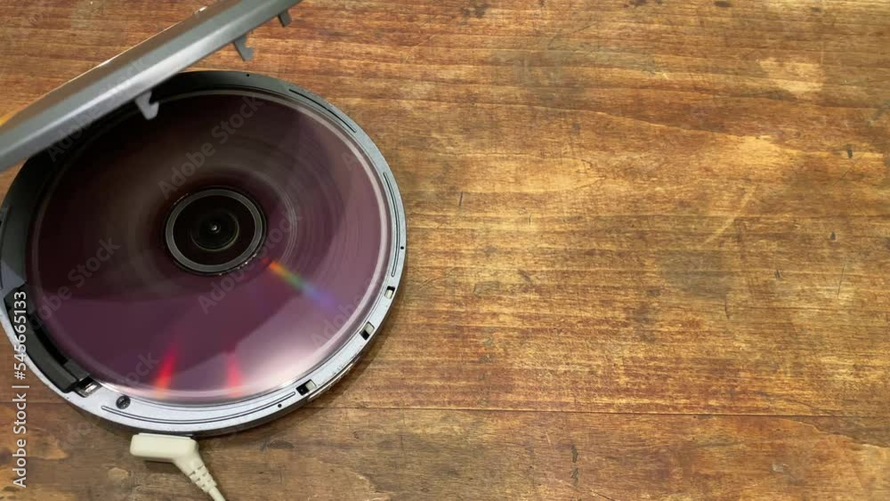 The CD is spinning in a player on a wooden table.Listening to music on the disc. CD player for playing music.