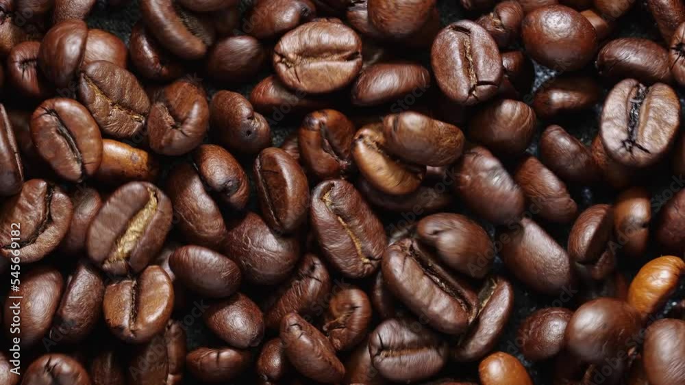 Fragrant fried coffee beans moving. Close-up of a coffee beans moving in a grinder. Fragrant fried coffee beans moving. Close-up of a coffee beans moving in a grinder.